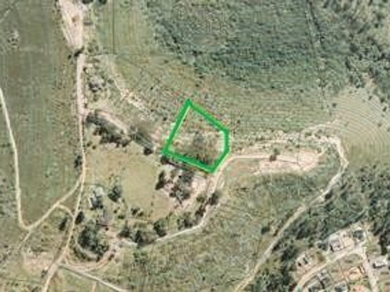 An aerial view of a vacant residential plot of land, highlighting the property boundaries and surrounding landscape.