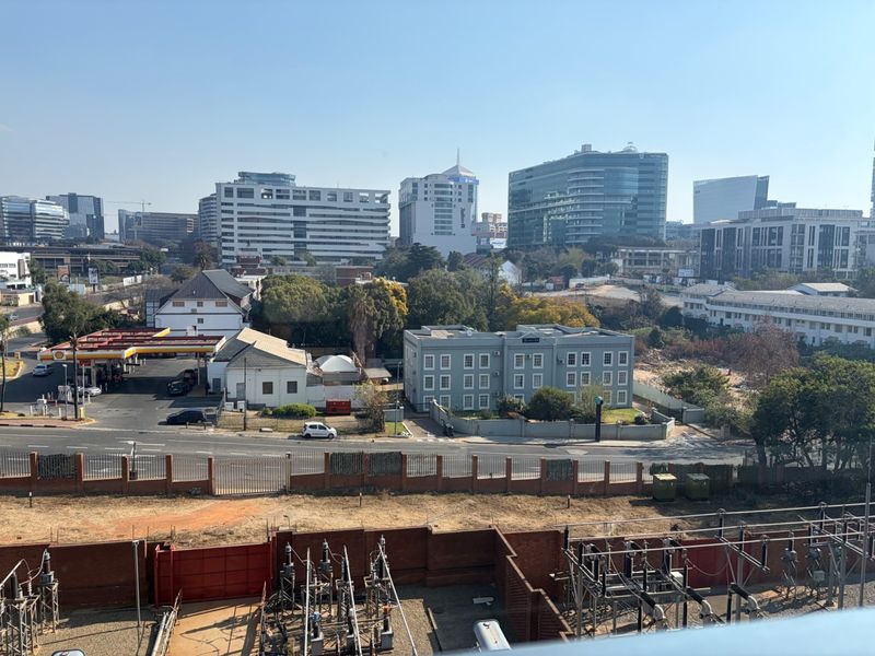 Elevated urban view overlooking surrounding commercial buildings, a petrol station, and local infrastructure.