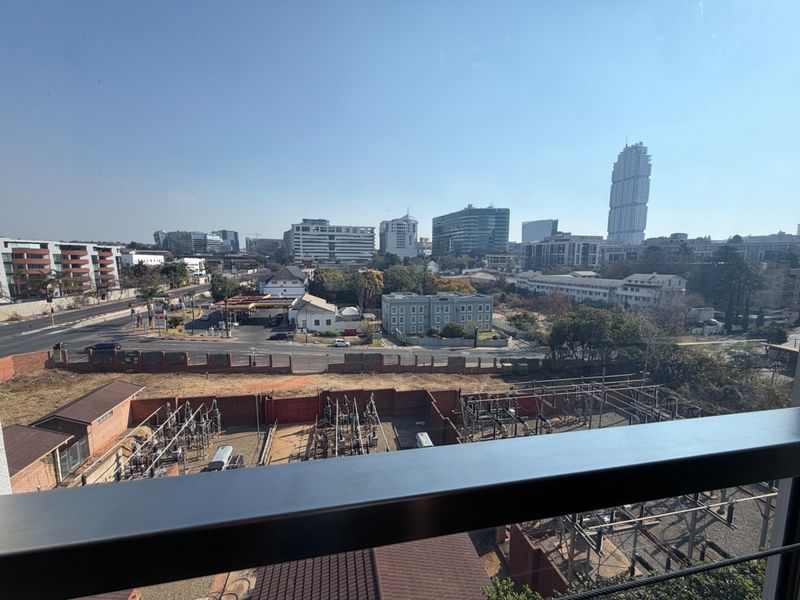 Elevated urban view overlooking the surrounding cityscape and infrastructure from a balcony.