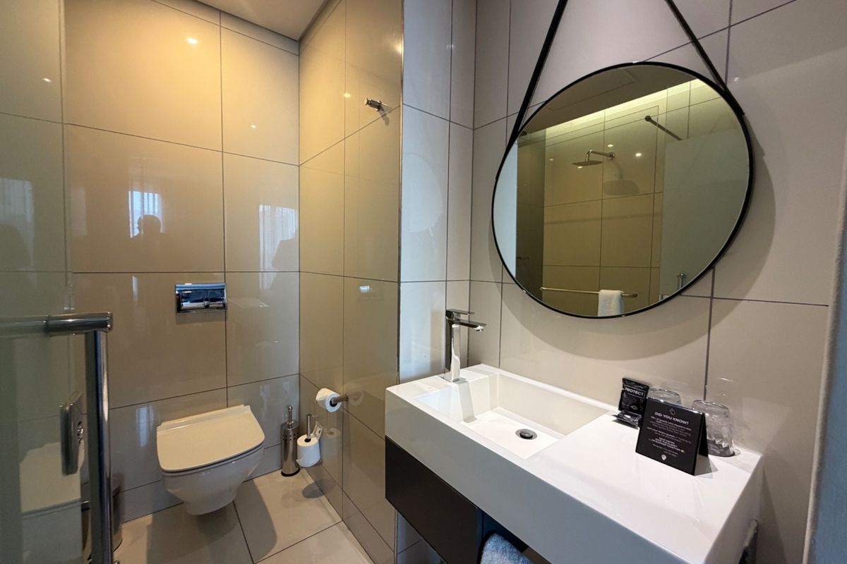 Modern bathroom featuring a floating vanity, wall-mounted toilet, and sleek tiled finishes with contemporary fixtures.