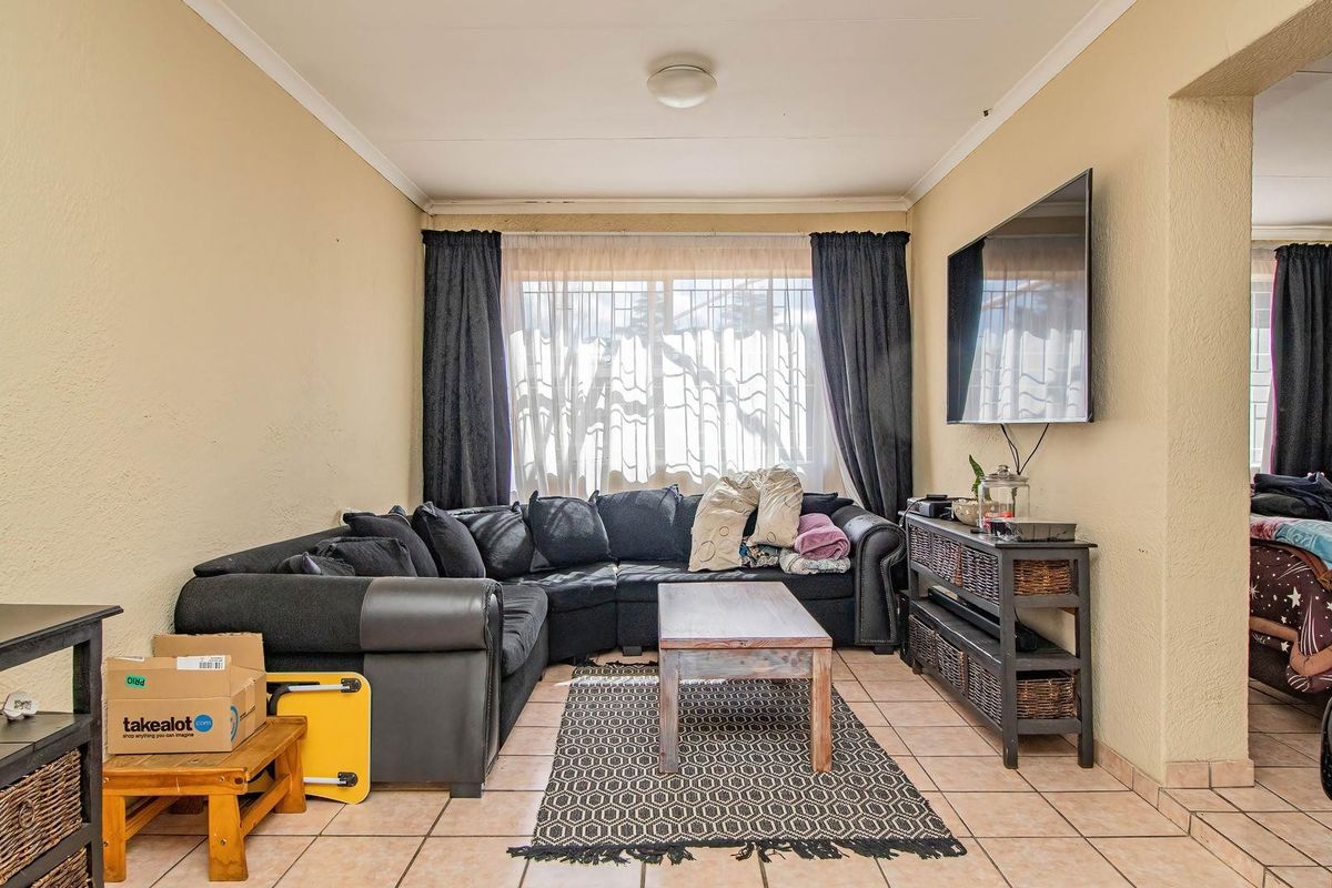 A functional living room featuring tiled flooring and neutral wall finishes, providing a comfortable and practical space for relaxation.