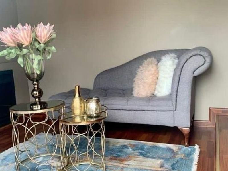 A cozy living area featuring warm-toned laminate flooring, skirting boards, and a built-in fireplace, creating a comfortable and inviting atmosphere.
