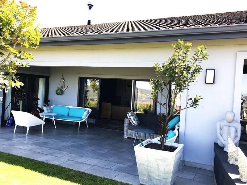 A covered patio area featuring large format floor tiles and sliding glass doors providing seamless access to the interior living space.