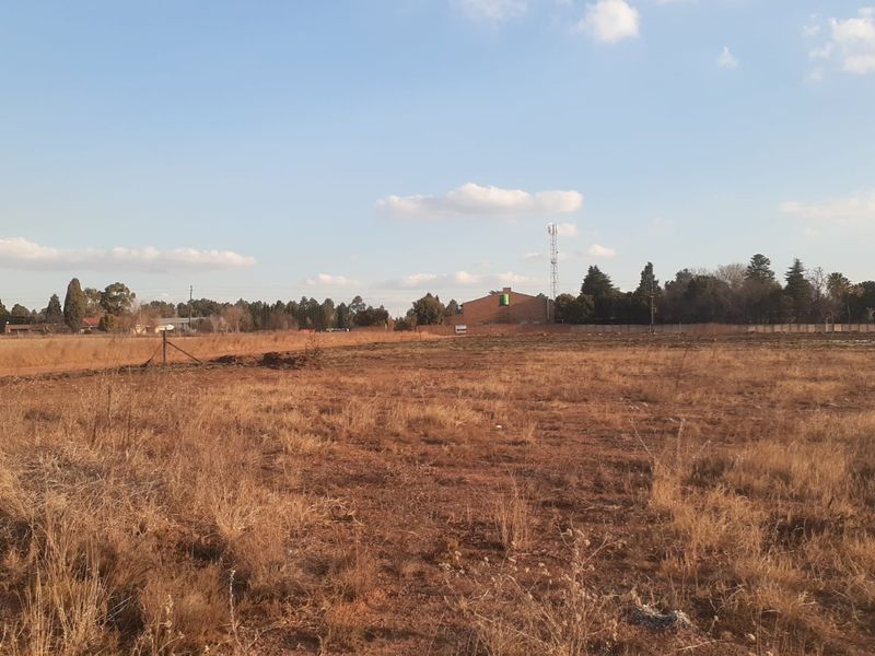 Expansive open land area featuring dry natural vegetation and perimeter fencing, suitable for development or agricultural use on this small holding.