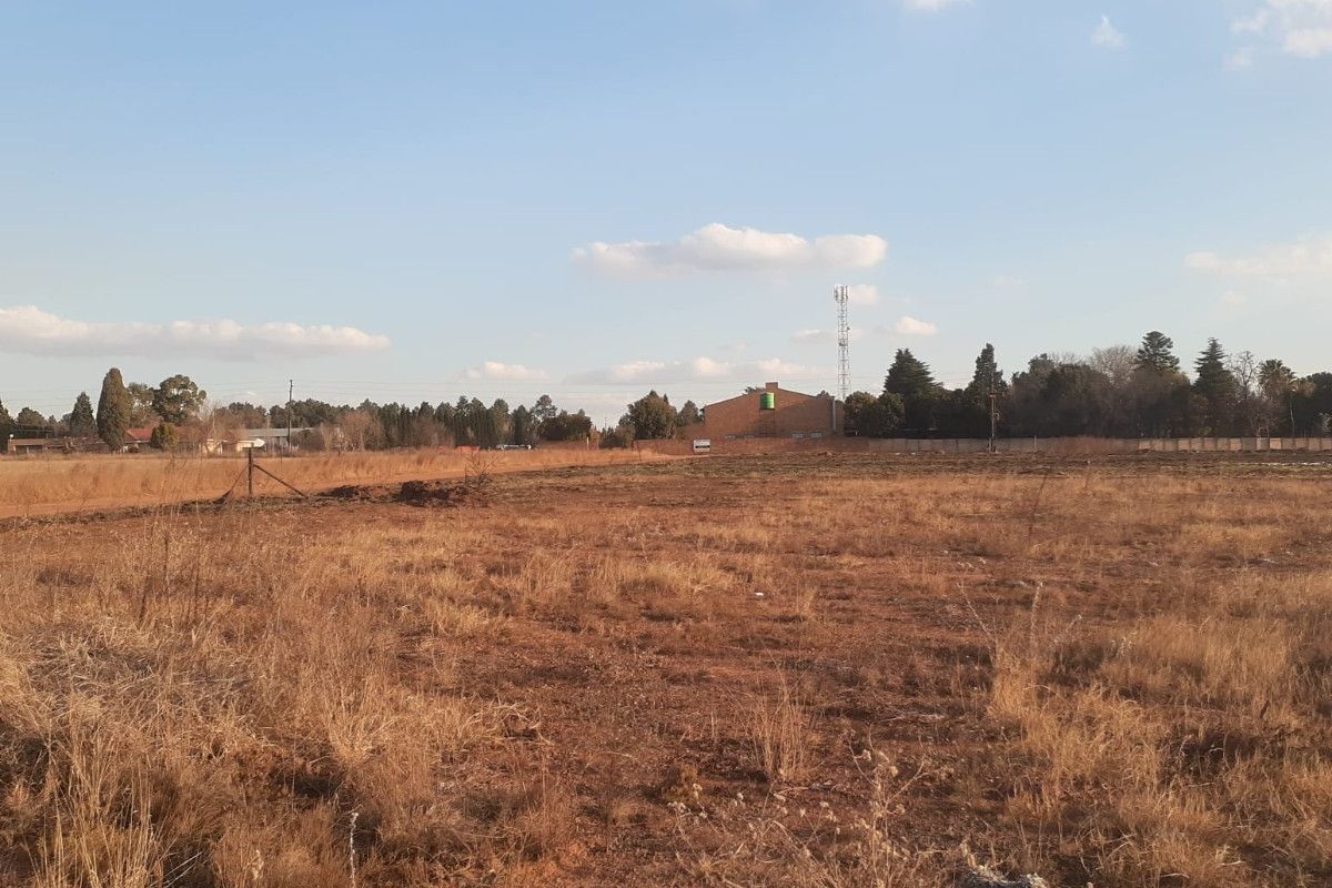 Expansive open land area featuring dry natural vegetation and perimeter fencing, suitable for development or agricultural use on this small holding.