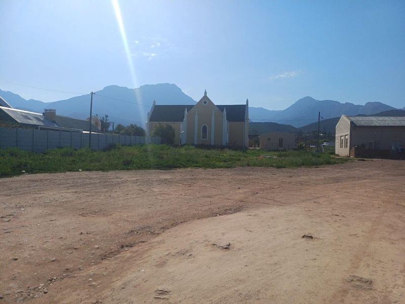 Street view of the property location featuring an unpaved access area with a clear view of the surrounding mountain landscape.