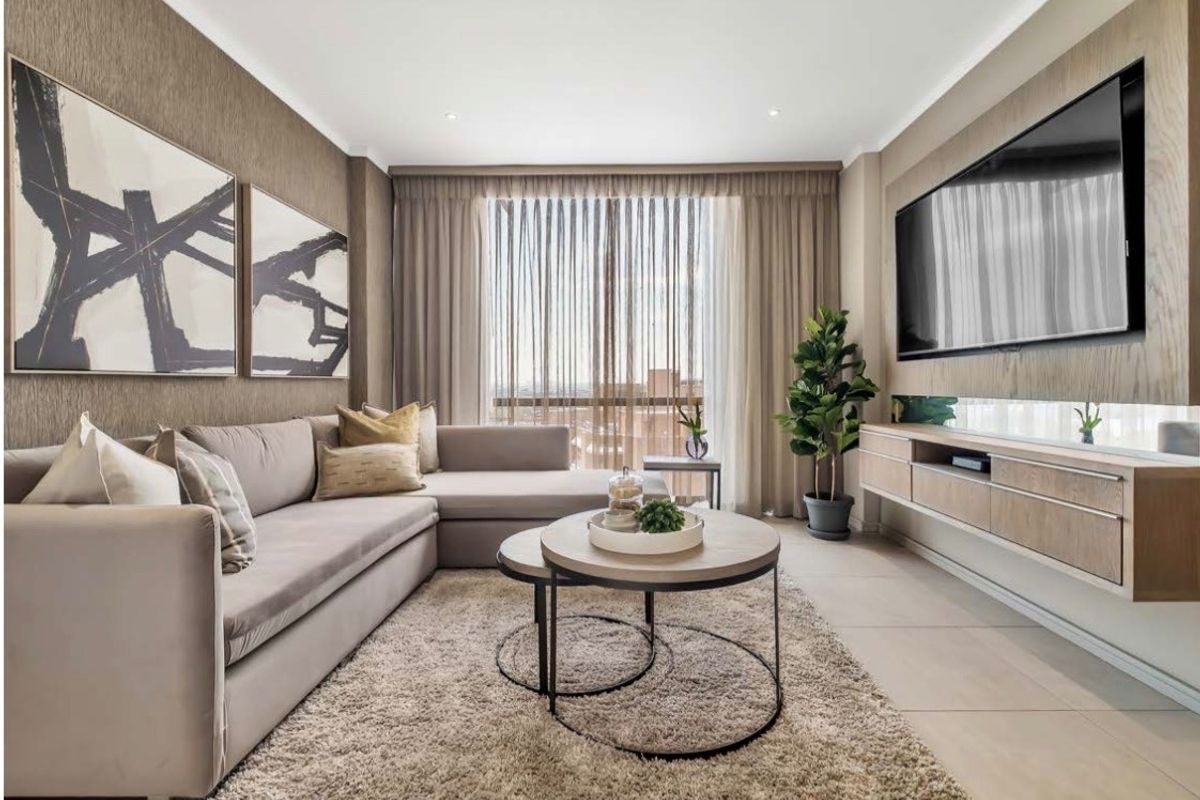 Modern living room featuring neutral tones, tiled flooring, recessed lighting, and custom wall-mounted cabinetry.