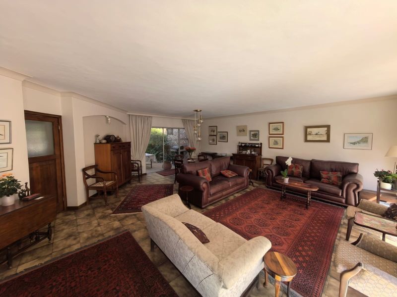 Spacious open-plan living and dining area featuring tiled flooring, coved ceilings, and a sliding glass door providing access to the outdoor patio.