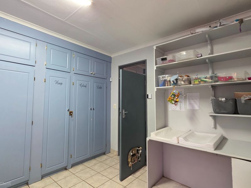 Bedroom featuring extensive built-in cabinetry, tiled flooring, and a functional built-in desk area with open shelving.