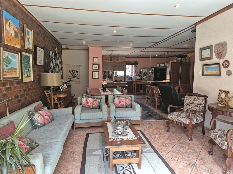 Spacious open-plan living and dining area featuring exposed brick walls, tiled flooring, and a connected kitchen space with built-in cabinetry.