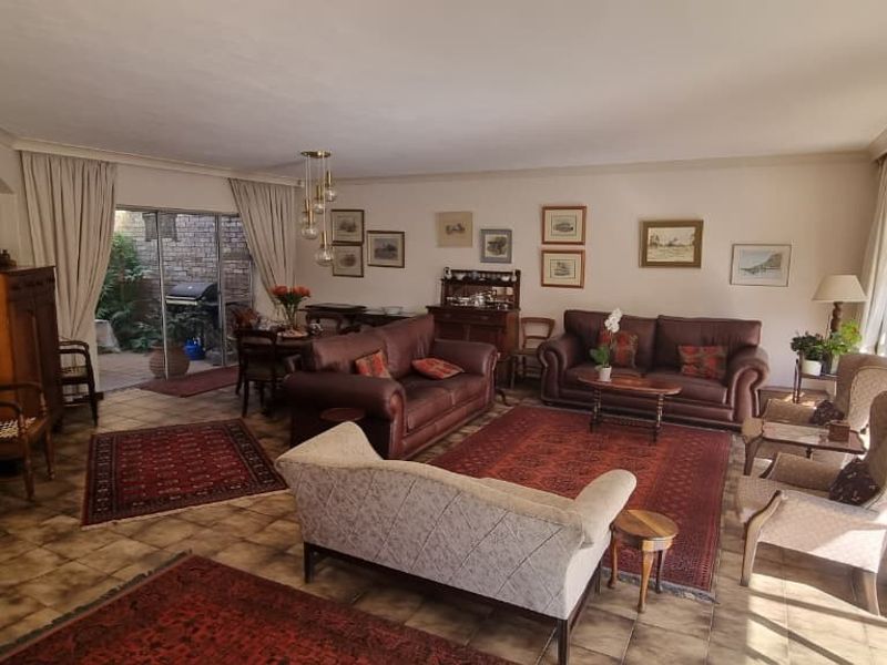 Spacious living room featuring tiled flooring, coved cornicing, and large sliding glass doors providing access to the outdoor patio area.