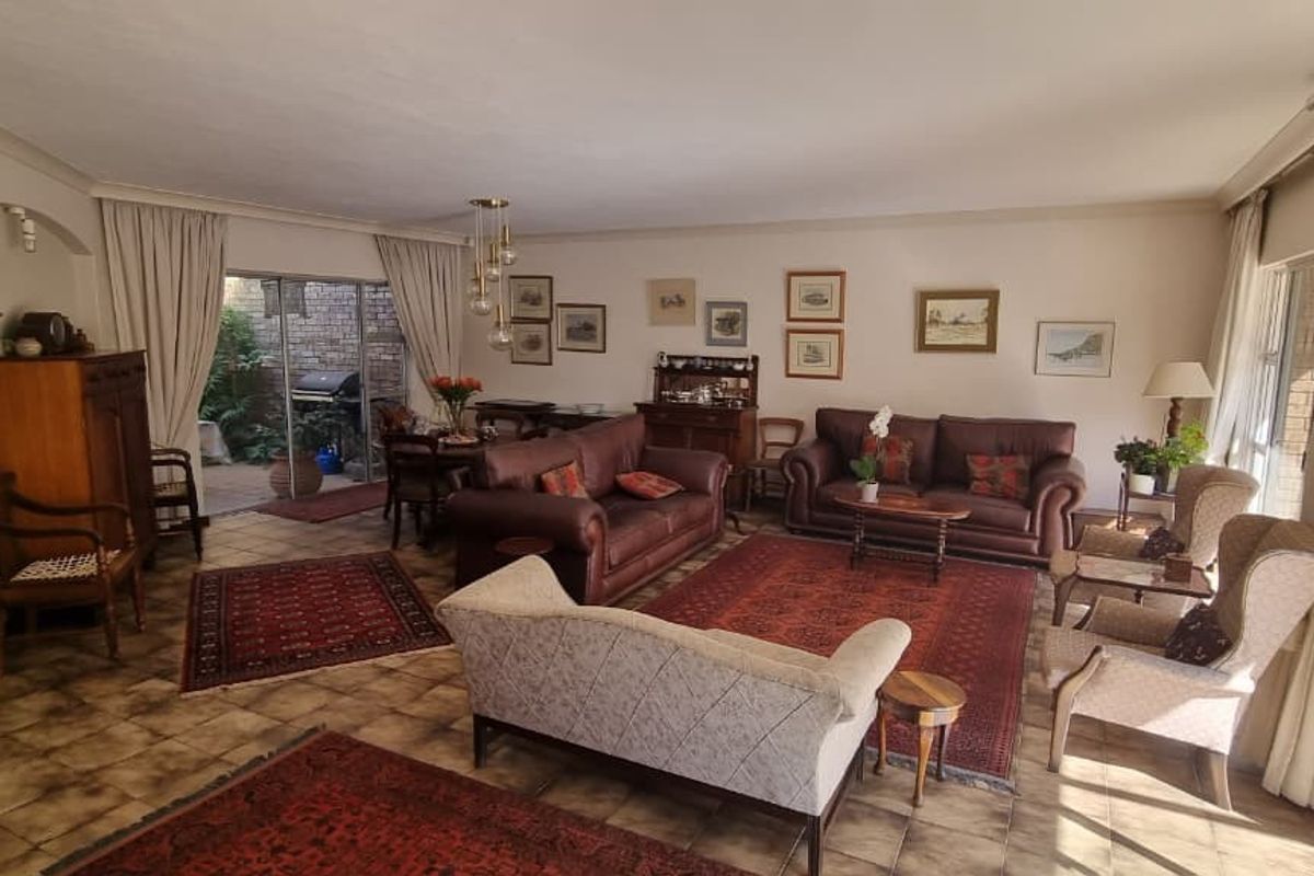 Spacious living room featuring tiled flooring, coved cornicing, and large sliding glass doors providing access to the outdoor patio area.