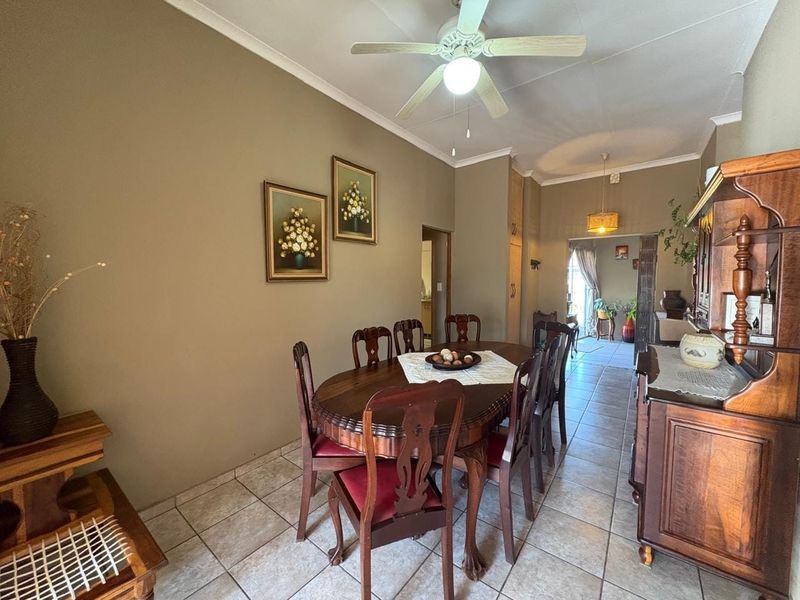 A dining room featuring tiled flooring, a ceiling fan, and built-in cabinetry, providing a functional space for family meals.