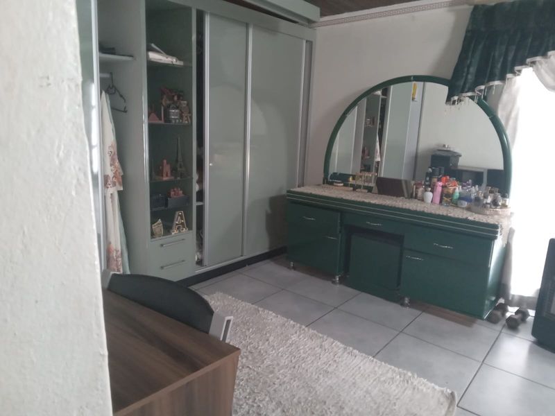 A bedroom featuring built-in wardrobes and tiled flooring, offering functional storage space.