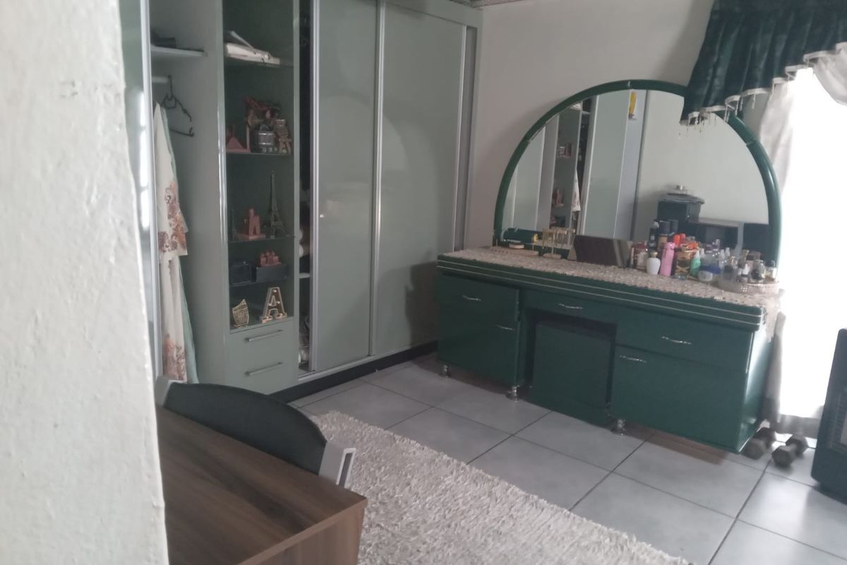 A bedroom featuring built-in wardrobes and tiled flooring, offering functional storage space.