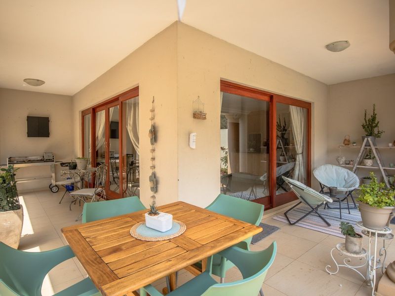 A covered patio area featuring tiled flooring, built-in columns, and large sliding glass doors providing seamless access to the interior living space.