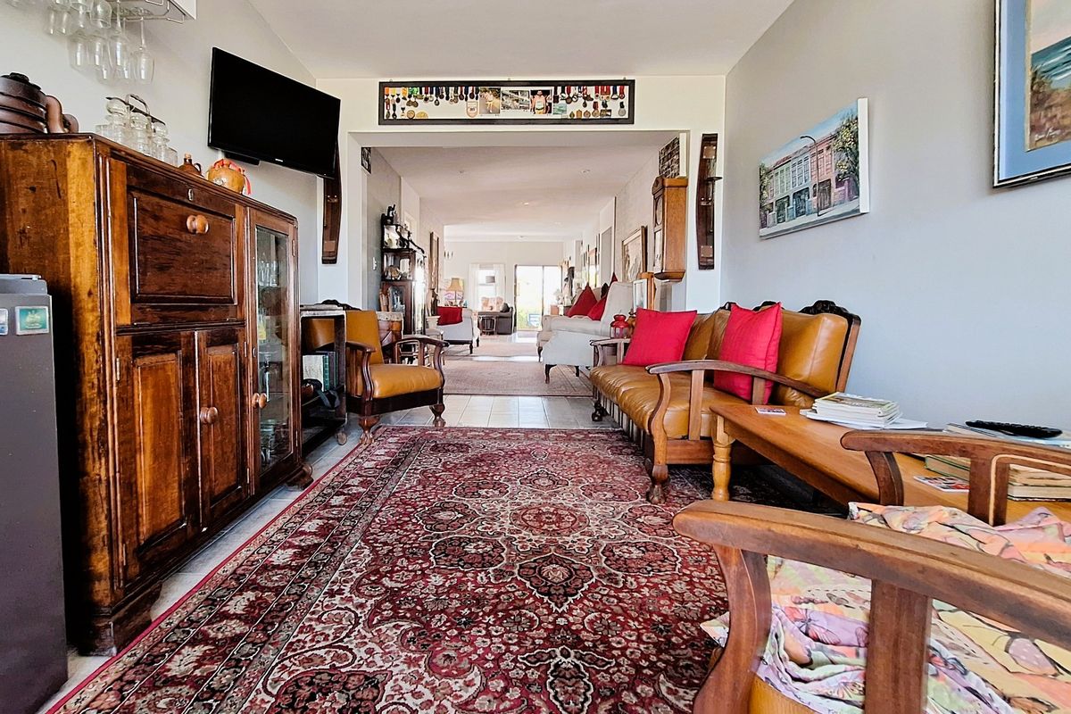 A spacious, open-plan living area featuring neutral walls, tiled flooring, and recessed lighting, offering a comfortable and versatile space for relaxation.
