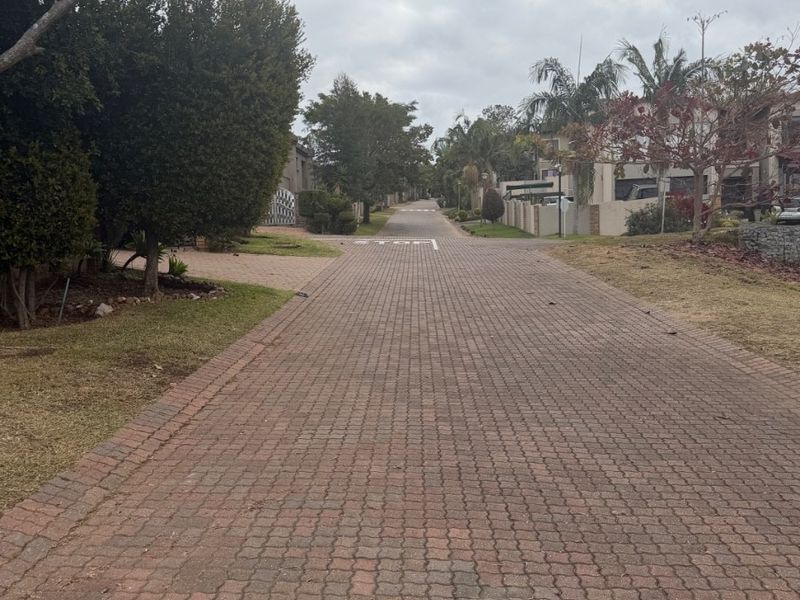 A view of the paved residential street and surrounding neighbourhood approach.
