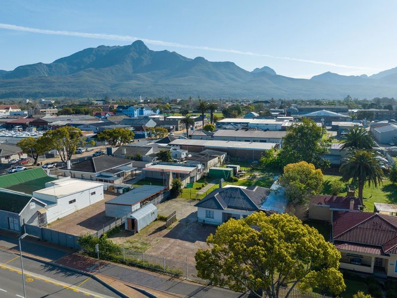 Aerial view of the commercial property and surrounding neighbourhood, featuring mountain views and established infrastructure.