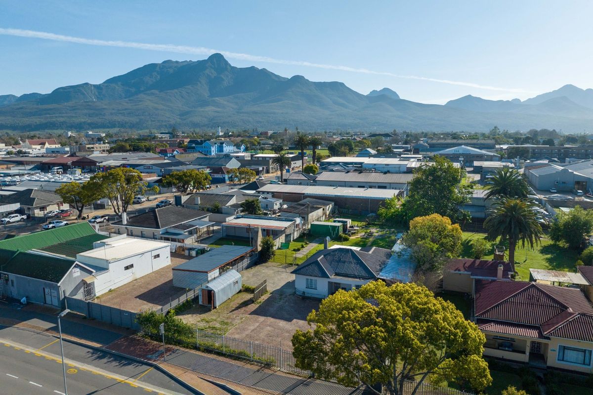Aerial view of the commercial property and surrounding neighbourhood, featuring mountain views and established infrastructure.