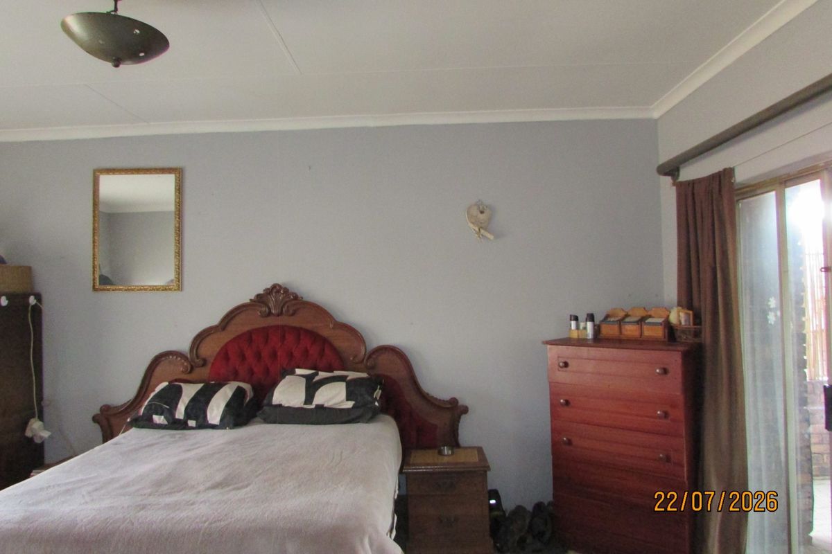 A bedroom featuring tiled flooring, a coved ceiling, and a sliding glass door providing access to the exterior.