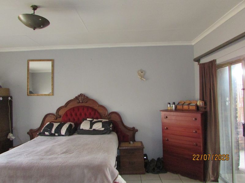 A bedroom featuring tiled flooring, a coved ceiling, and a sliding glass door providing access to the exterior.