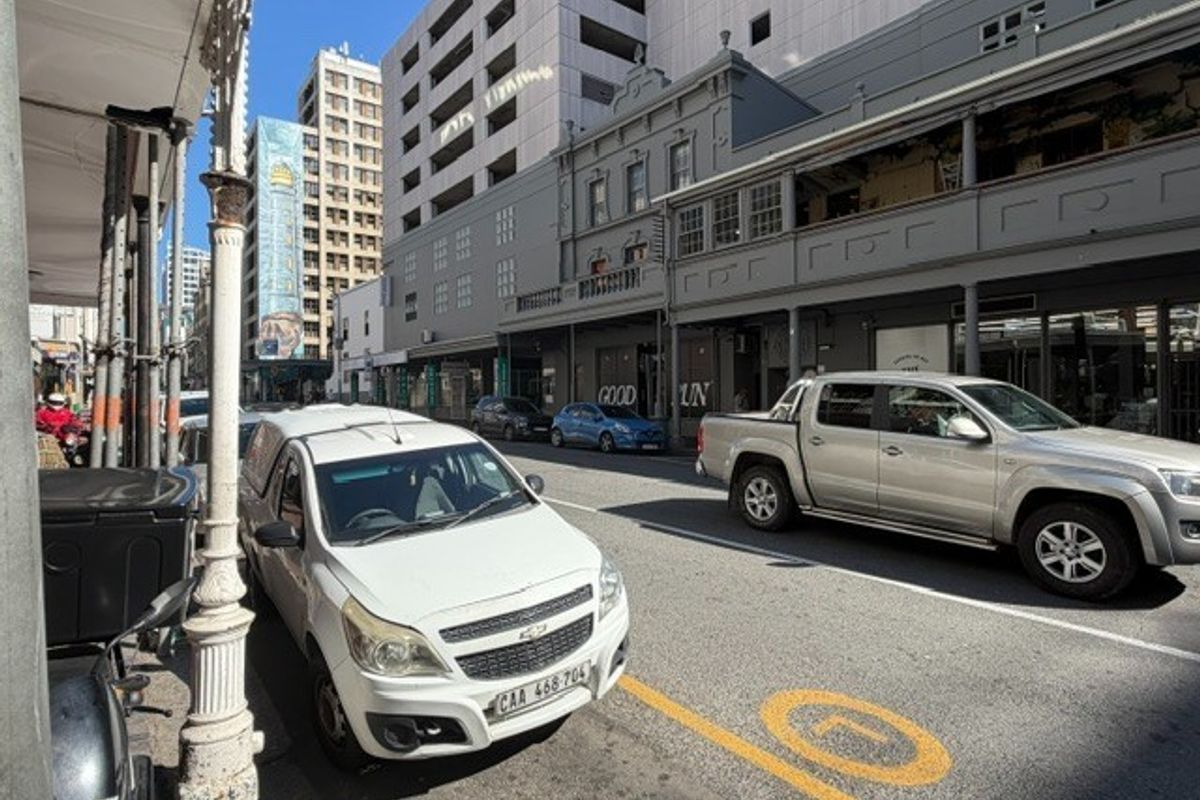 Street level view of a commercial office building facade featuring historic architectural details and a covered pedestrian walkway.