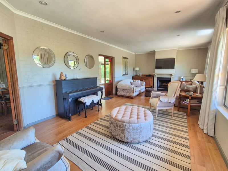 Spacious living room featuring laminate flooring, a central fireplace, and recessed lighting, offering a comfortable and well-maintained living space.