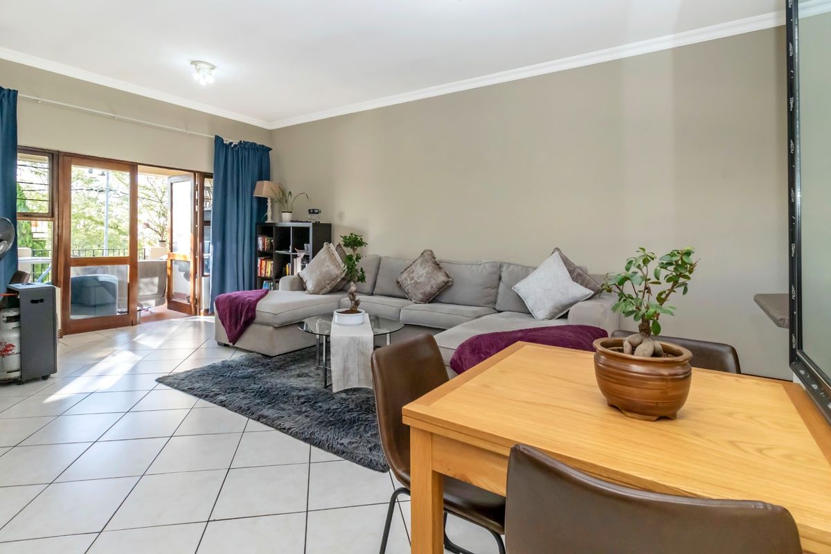 Spacious living area featuring tiled flooring and a sliding glass door providing access to an outdoor balcony.
