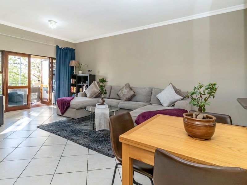 Spacious living area featuring tiled flooring and a sliding glass door providing access to an outdoor balcony.