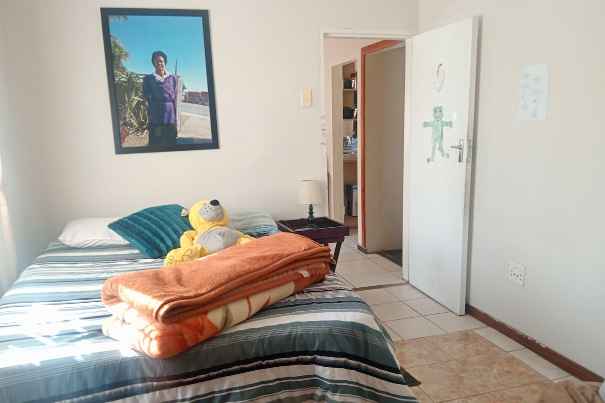 A bedroom featuring tiled flooring and access to an adjacent room through an internal doorway.
