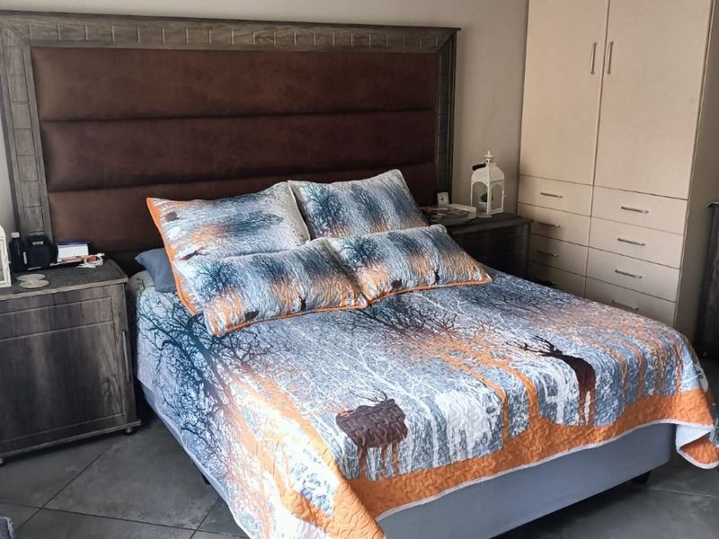 A bedroom featuring tiled flooring, crown molding, and a built-in wardrobe providing ample storage space.