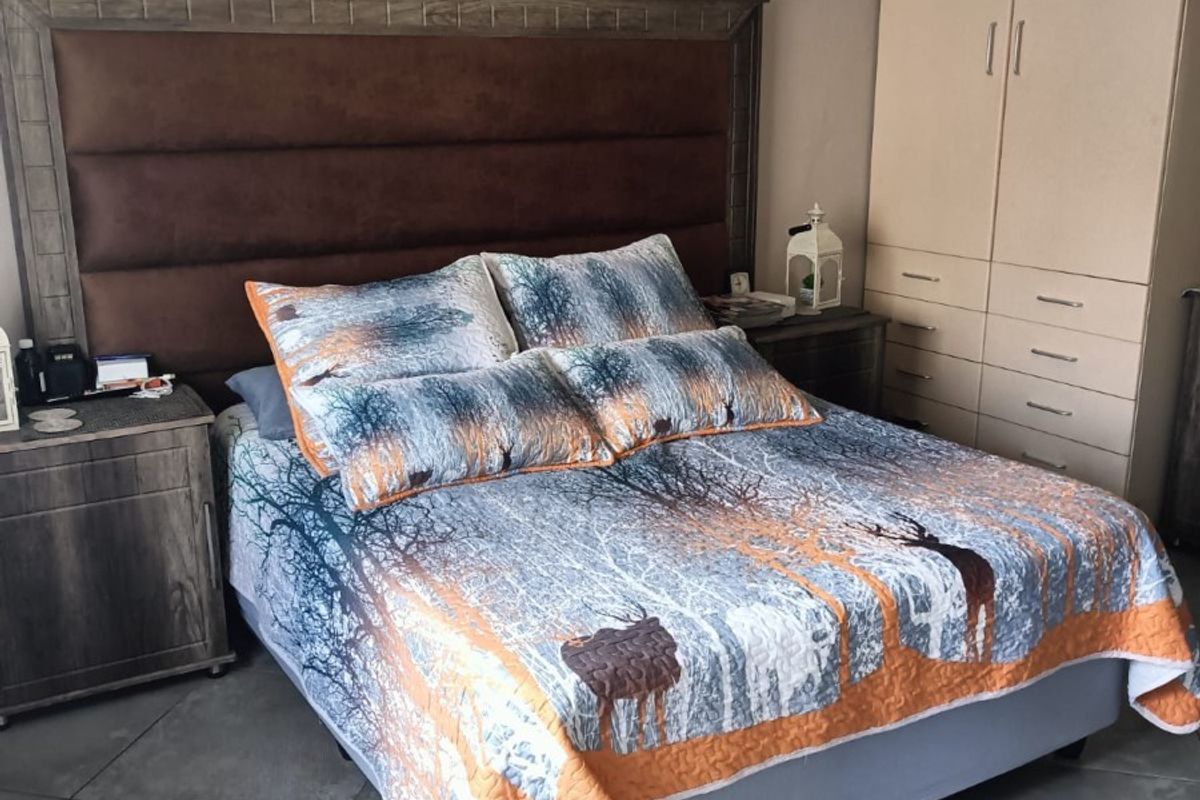 A bedroom featuring tiled flooring, crown molding, and a built-in wardrobe providing ample storage space.