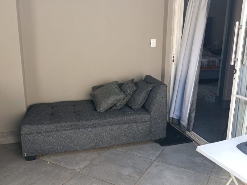 A covered patio area featuring tiled flooring and a sliding glass door providing access to the interior living space.