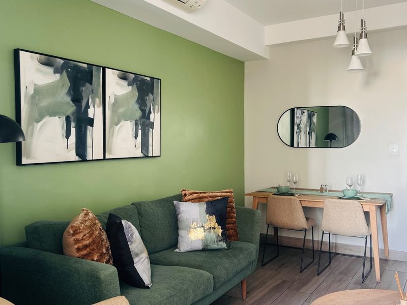 A well-maintained open-plan living and dining area featuring modern tiled flooring, neutral wall finishes, and integrated climate control.