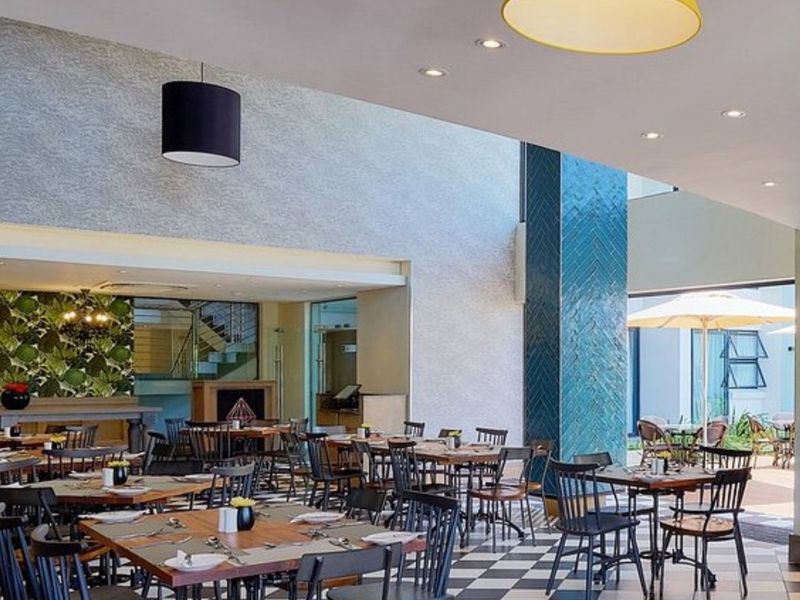 Spacious open-plan dining area featuring modern tiled flooring, decorative feature walls, and integrated recessed lighting, creating a sophisticated atmosphere.
