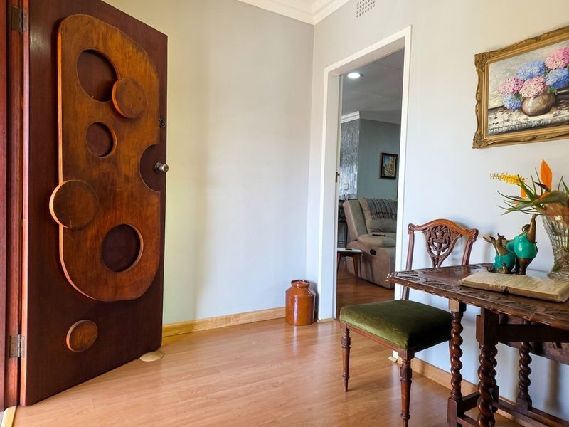 An entry area featuring laminate flooring and a unique decorative wooden door, leading into the main living space.