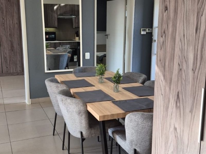 A well-maintained dining area featuring modern tiled flooring and neutral wall tones, providing a clean and functional space for meals.