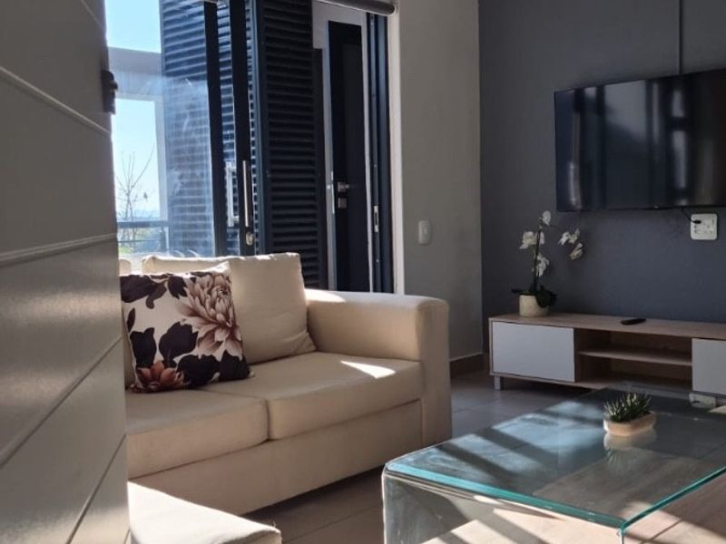 Modern living room featuring tiled floors, a split-system air conditioner, and a sliding glass door leading to an outdoor area.