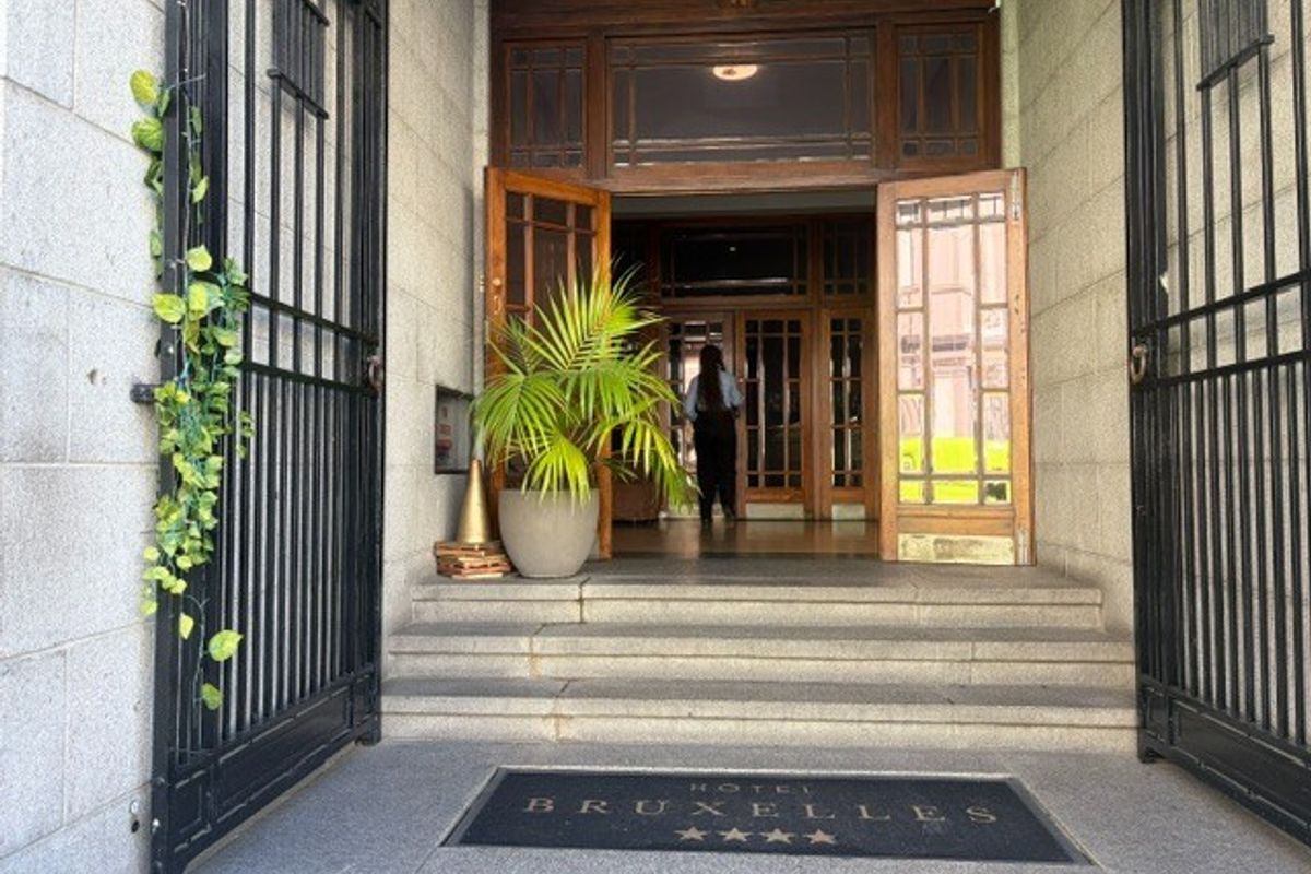 Grand entrance featuring stone steps, wrought iron gates, and classic timber-framed glass doors leading into the restaurant lobby.