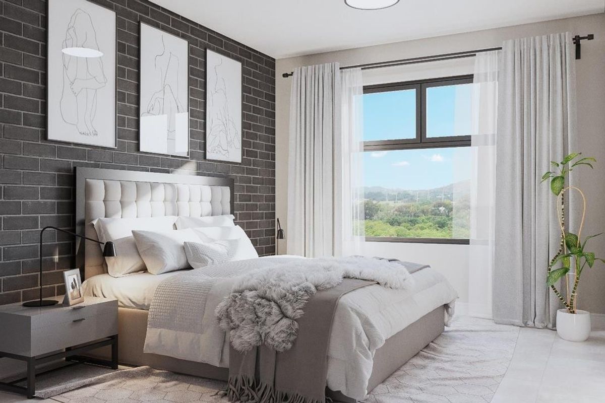 A modern, well-lit bedroom featuring a stylish dark brick accent wall, large window with natural light, and neutral contemporary finishes.