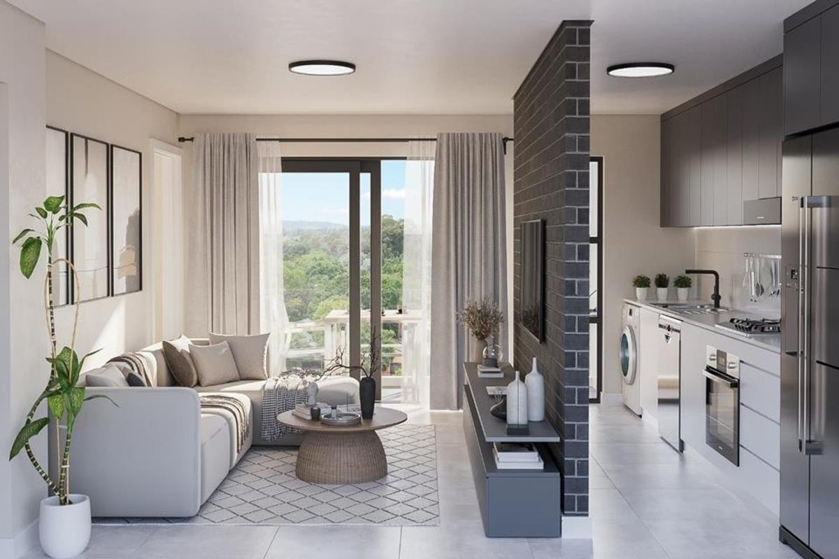 Modern open-plan living area featuring a sleek kitchen with built-in appliances, a brick feature wall, and sliding doors leading to a balcony.