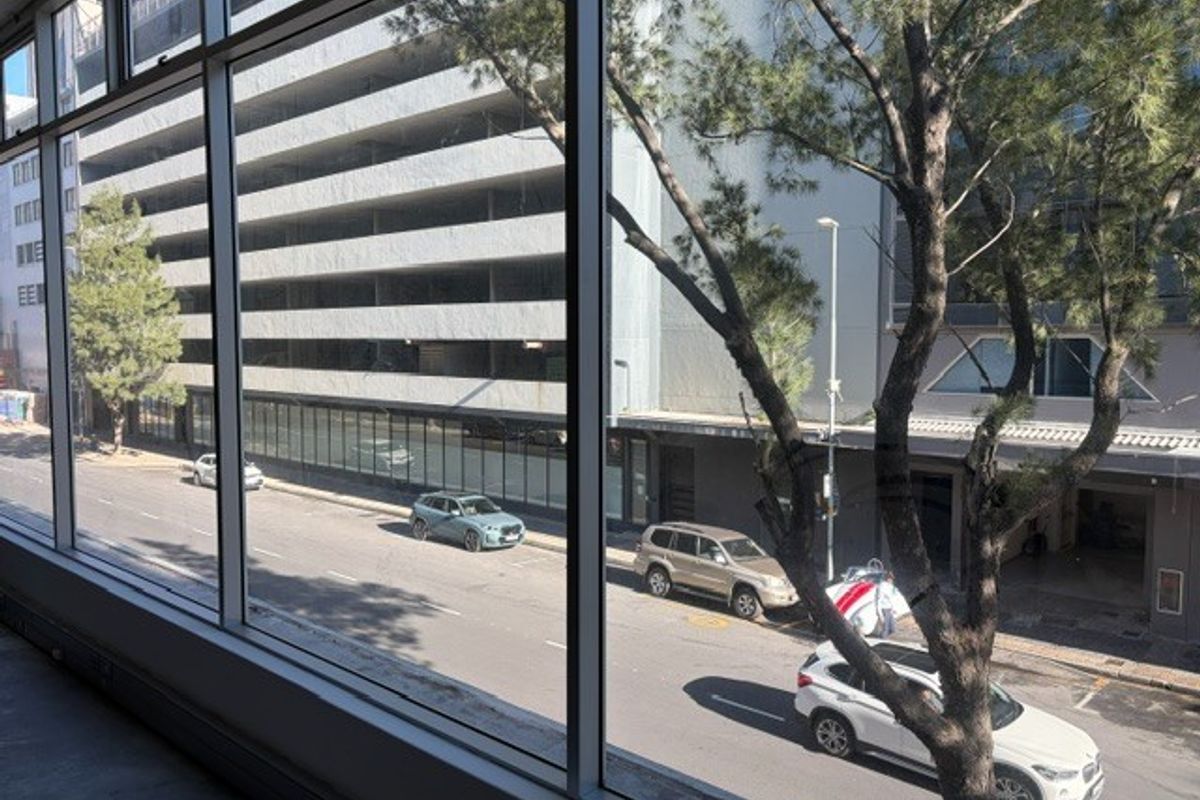A view from an office window overlooking a city street and adjacent parking structure.