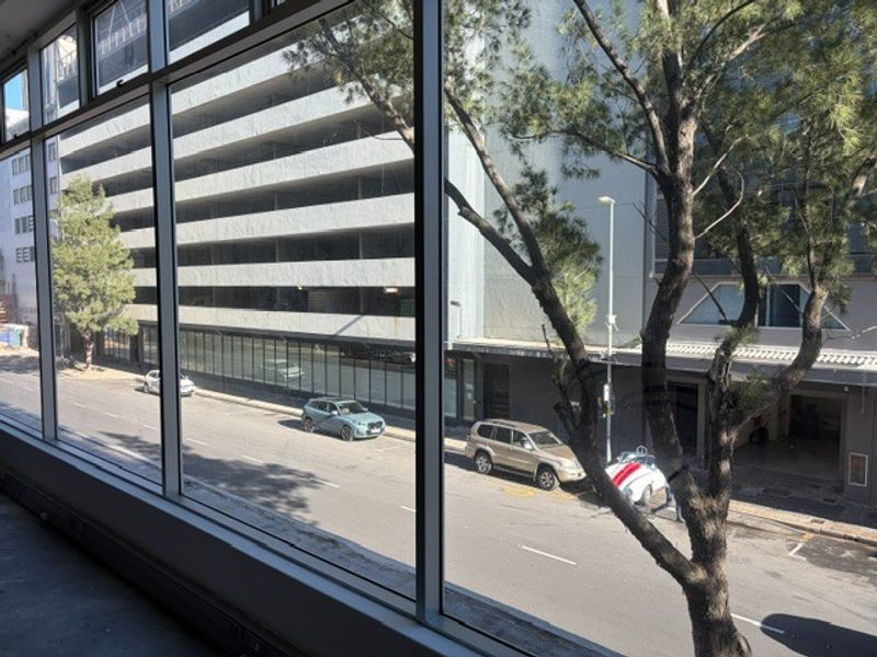 A view from an office window overlooking a city street and adjacent parking structure.