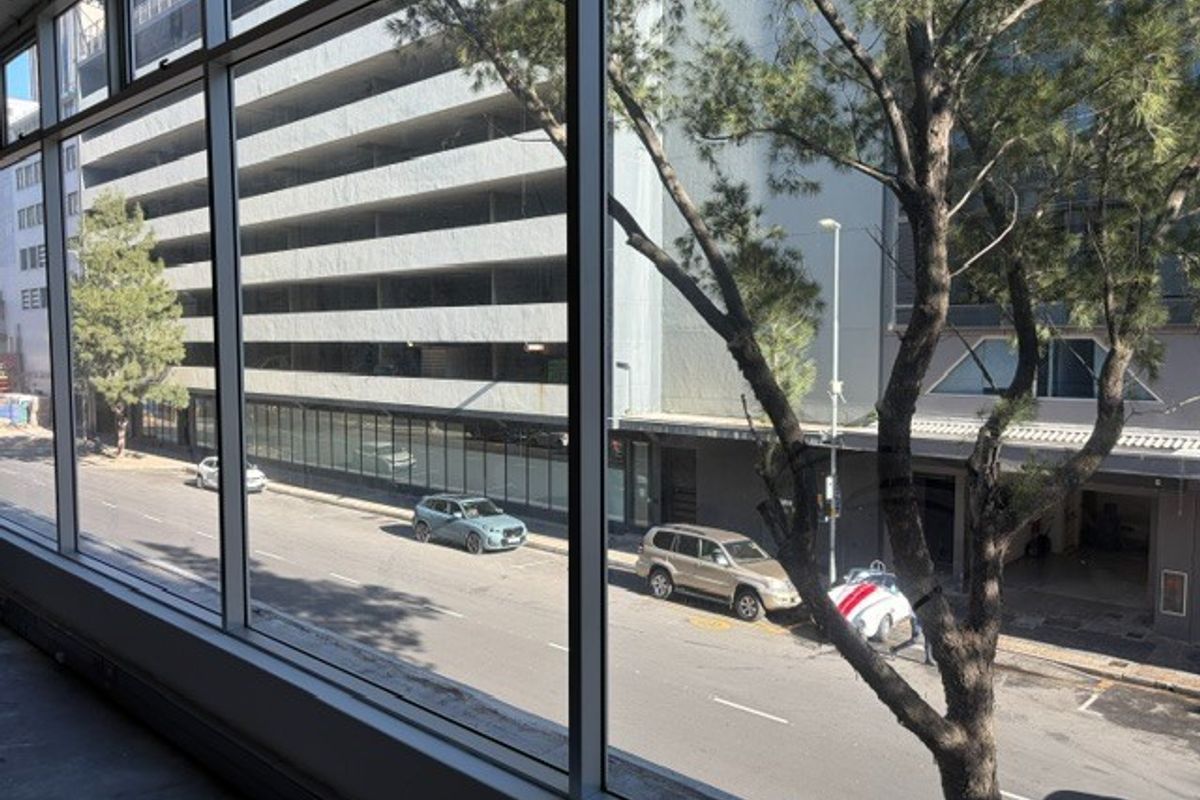 A view from an office window overlooking a city street and adjacent parking structure.