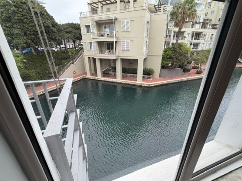A view from an office window overlooking a canal and adjacent residential building complex.