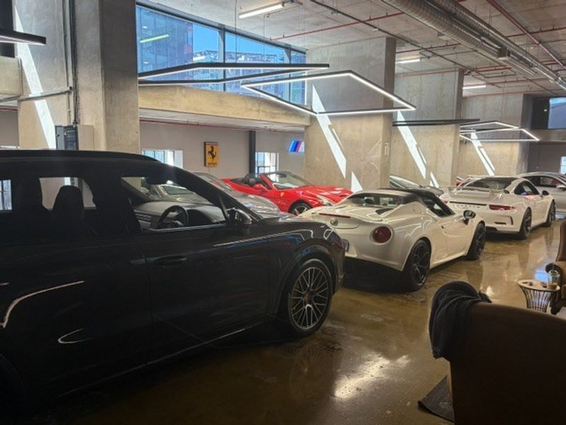 Spacious industrial-style garage featuring polished concrete floors, exposed structural columns, and modern linear LED lighting fixtures.