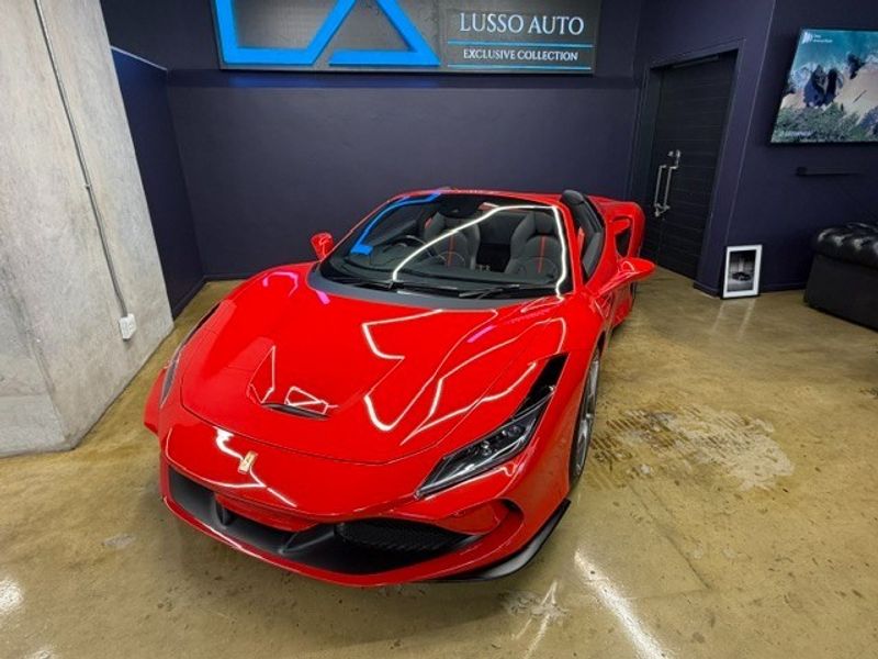 A modern, well-maintained garage space featuring polished concrete floors and dark feature walls, currently utilized as a premium vehicle display area.