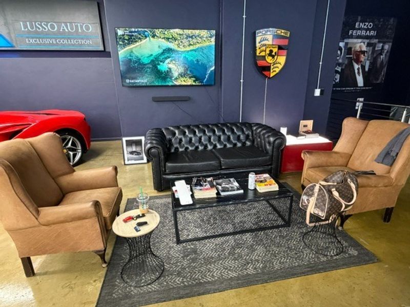 A lounge area within a commercial showroom space featuring polished concrete floors and dark painted walls.