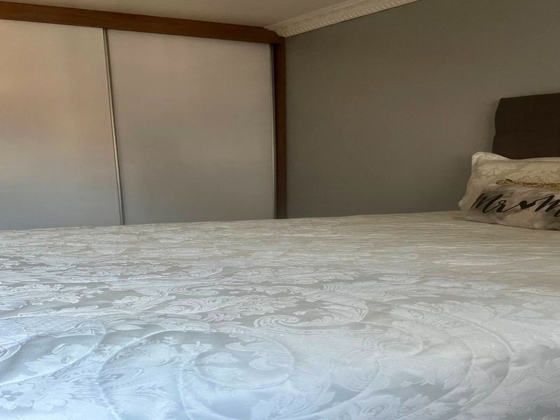 A bedroom featuring a built-in sliding door wardrobe and decorative crown molding.